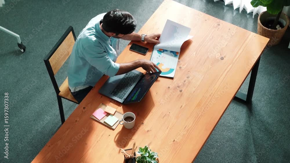 Poster top view of business man working on laptop while looking at financial chart. manager with casual clo