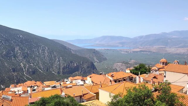 Panoramic view from Delphi over the ancient Crisaean Plain, blanketed with olive trees, stretching down to the Gulf of Itea and the seaside towns of Itea and Kyrra, backed by distant mountain ranges.