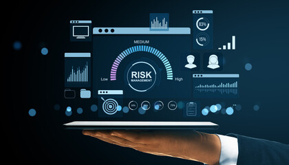 Digital interface showing risk management dashboard with financial data analysis and user icons on a tablet held by a hand on dark background.