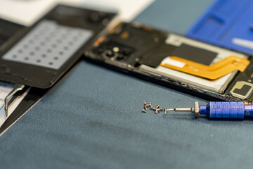 Fototapeta premium Professional Phone Repair With Tools and Components Laid out on a Workbench in a Workshop