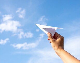 Hand launching a paper airplane into the sky, freedom and imagination theme