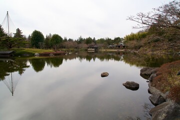Japanese garden and pond under cloudy sky