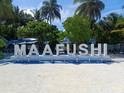 Maafushi, Maldives - 11 April 2025: A large sign spelling out "MAAFUSHI" in white, three-dimensional letters, standing on a sandy beach. Related to tropical island tourism, specific travel destination