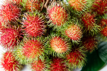 Fresh rambutan fruit on white wooden table.