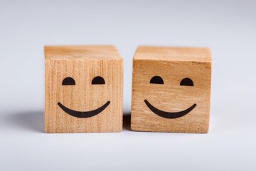 Two wooden cubes with cheerful smiley faces creating a warm and friendly atmosphere ideal for conveying happiness, positivity, joy, and emotional connection in creative design concepts
