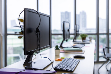 Call center office interior with headsets and computer workstations by window