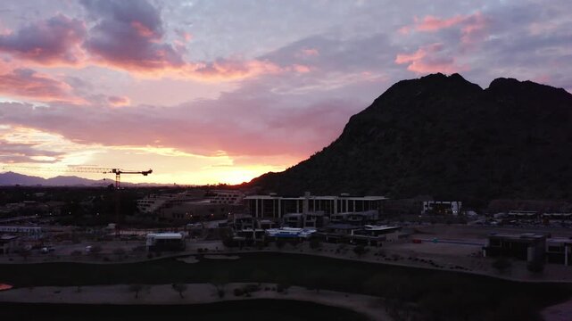 Drone shot of The Phoenician resting under the setting sun and Camelback Mountain in Arizona.