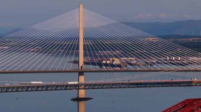 Aerial video of the Forth road Bridge in Edinburgh Scotland with Queensferry crossing Bridge on the backgroun