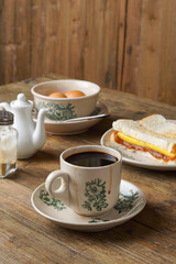 Traditional Malaysian Kopitiam Breakfast Set with Half-Boiled Eggs, Kaya Toast, and Black Coffee on the table
