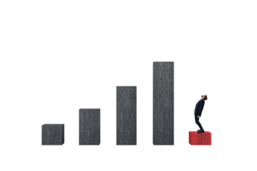Businessman in suit stands on red block, gazing up at ascending staircase of wood-textured blocks arranged on isolated white background