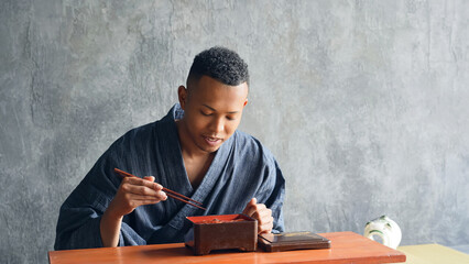 A foreign man wearing a kimono eating eel rice