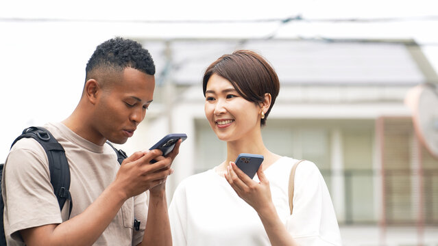 外国人、スマホ、旅行、道案内、旅行者、スマートフォン、カップル、インバウンド、案内、翻訳、アプリ、英会話、観光客、日本人、男性、女性、ガイド、若い、黒人、アフリカ系、ゲスト、観光、海外、グローバル、訪日、日本、留学、都市、通訳、日本語、英語、語学、おもてなし、コミュニケーション、交流、ボランティア、説明、教える、ナビゲーション、観光地、紹介、笑顔、屋外、地図、リュックサック、カジュアル、DX、モバ - Powered by Adobe