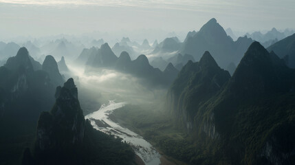 Misty mountain range with river flowing through the valley at early morning