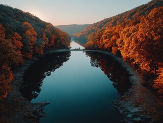Aerial view of a scenic river valley during autumn with fall foliage and reflections at sunset.