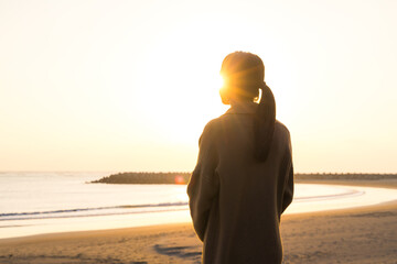 Woman enjoy sunset silhouette by the sea