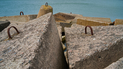 Concrete blocks at seashore as wave breakers