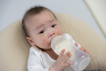 Infant Enjoying Bottle Feeding At Home