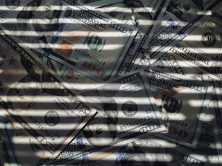 The horizontal shadow of the blinds resembles the grid on dollar bills. The concept of prison,...