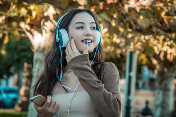 young woman dancing with headphones on the street