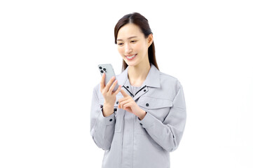 携帯電話を使う作業服の女性　作業員　工場