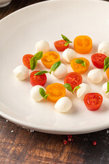 Colorful Caprese salad with cherry tomatoes, mozzarella and fresh basil