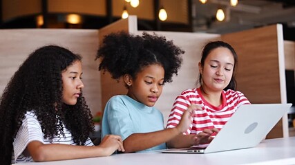 A group of Asian and Caucasian black girls sit together studying in a library, happy to have gotten their homework done correctly and completed. - Powered by Adobe