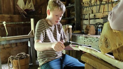 Boy uses Shaving Horse to Do Woodworking in an Old Fashioned Woodshop