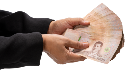 Hand holding a stack of Thai baht banknotes isolated on white with clipping path , concept of payment, corruption, or financial transaction