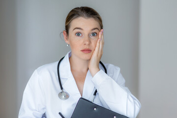 Concerned female doctor with stethoscope looking worried in a medical setting