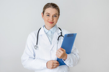 Confident female doctor holding clipboard and wearing stethoscope in white attire