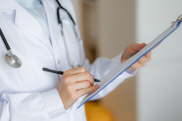 Medical professional documenting notes on a clipboard during a consultation