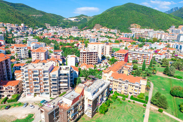 Aerial view of Budva, Montenegro, featuring a vibrant town with colorful buildings nestled between...
