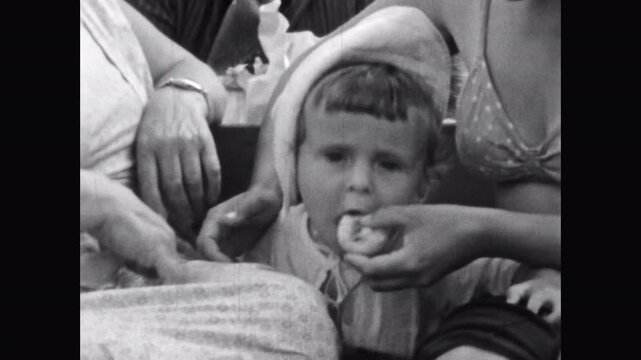 Portrait, child eating food from mother hand, close up. Old black white video, parent feeding little girl fruit. Grandmother family care for toddler. Archival retro film. Archival vintage 1960s