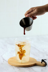 Pouring Americano to the Glass with Coconut Water