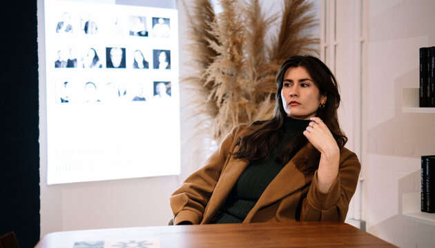 Portrait of a woman with brown hair indoors in London wearing autumn coat