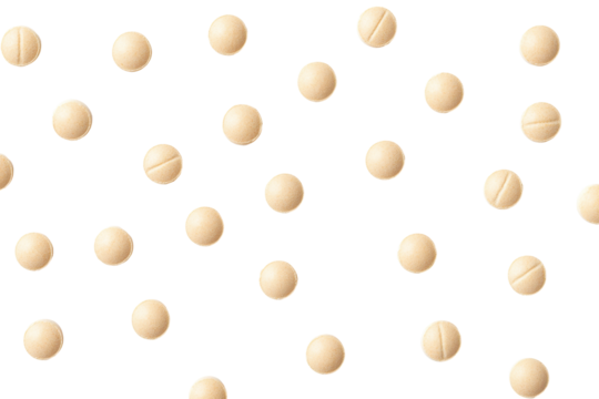 Scattered round beige pills with a dividing line isolated on transparent background.