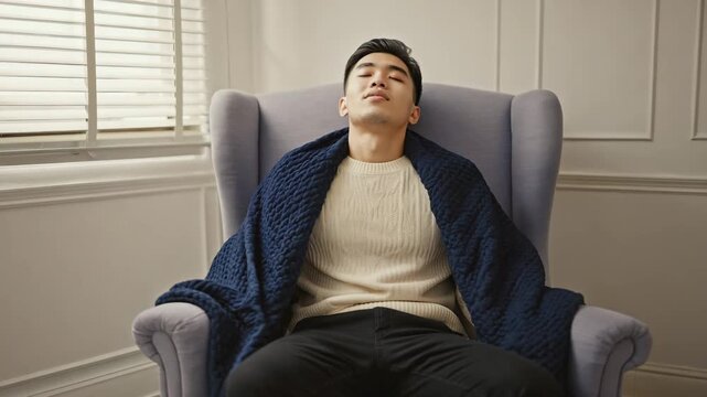 Man sitting quietly with weighted blanket, breathing deeply and calming down, peaceful mental health moment in 4K