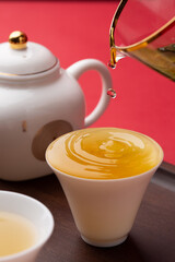 Tea leaves and tea set interior scene, pouring tea from kettle into cup
