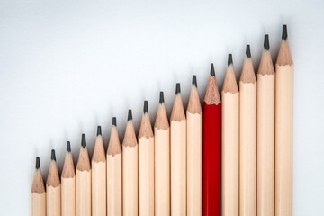 Naklejka premium Standing Out from the Crowd – Unique Red Pencil Among Ordinary Pencils