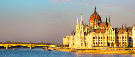 Obraz premium Vibrant color view of hungarian Parliament building, Danube and bridge at sunset, Hungary