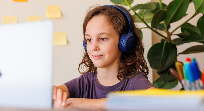 boy at school. boy in headphones sits in front of laptop in class. - Powered by Adobe