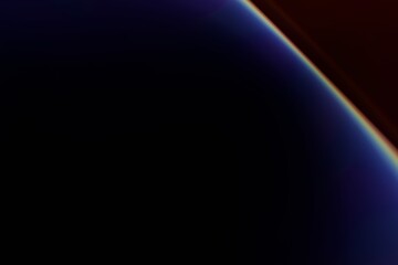 An abstract image featuring a vibrant, iridescent arc against a dark, almost black background. The arc displays a spectrum of colors, transitioning from deep blues 