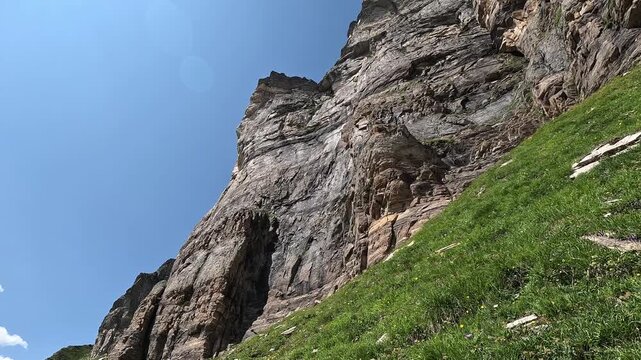 Sheer Rock Face and Jagged Cliff Above Alpine Meadow on a Clear Summer Day in Alpe Devero, Italian Alps