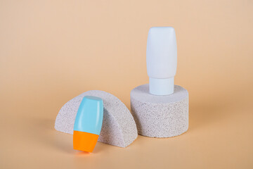 Cosmetic product in tube, bottle, lotion or serum with stylish props on cream background. 