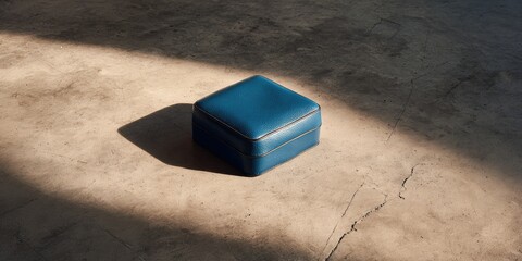 A simple blue leather box on a concrete floor