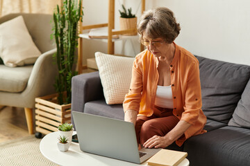 Senior woman enjoying a cozy afternoon at home while using her laptop for online activities