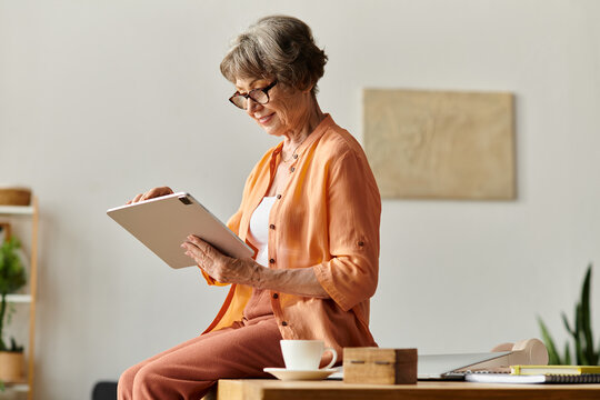 Senior woman enjoys quiet moments at home with a tablet surrounded by cozy decor - Powered by Adobe