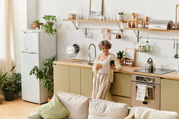 Cozy senior woman enjoying her home in comfortable attire while sipping tea in the kitchen