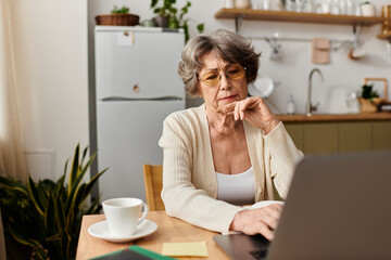 Senior woman enjoys peaceful morning at home while engaging with her laptop in cozy attire