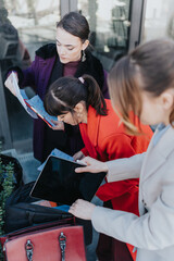 Three women working together outdoors, reviewing documents and using a tablet, exemplifying...